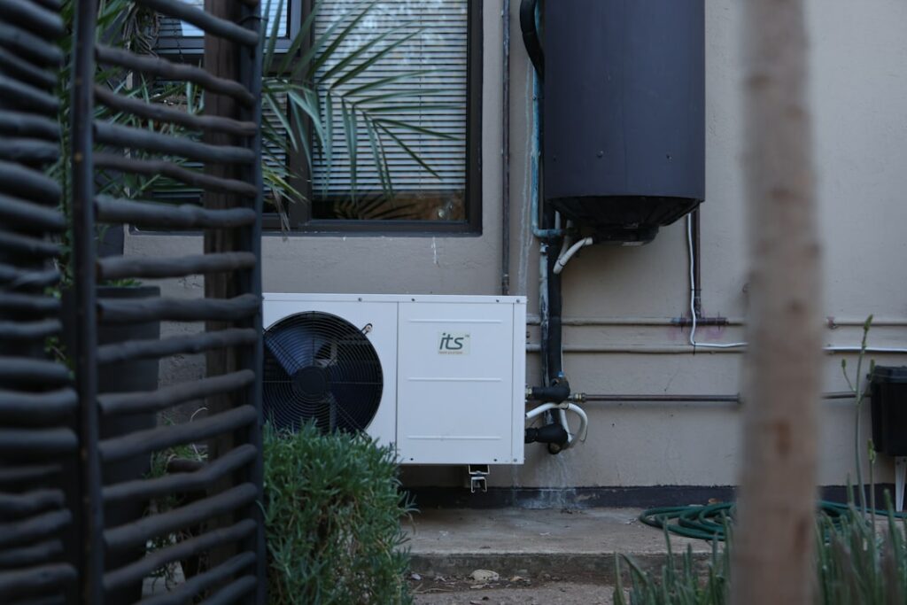 White outdoor air conditioning unit on a building wall