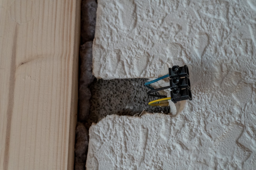 Ouvrier posant une contre-cloison isolante pour l'isolation des murs par l'intérieur